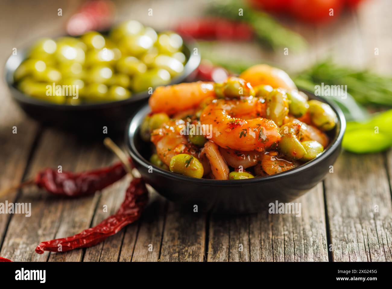 Salade fraîche avec des crevettes et des graines de soja edamame dans un bol sur une table en bois. Banque D'Images