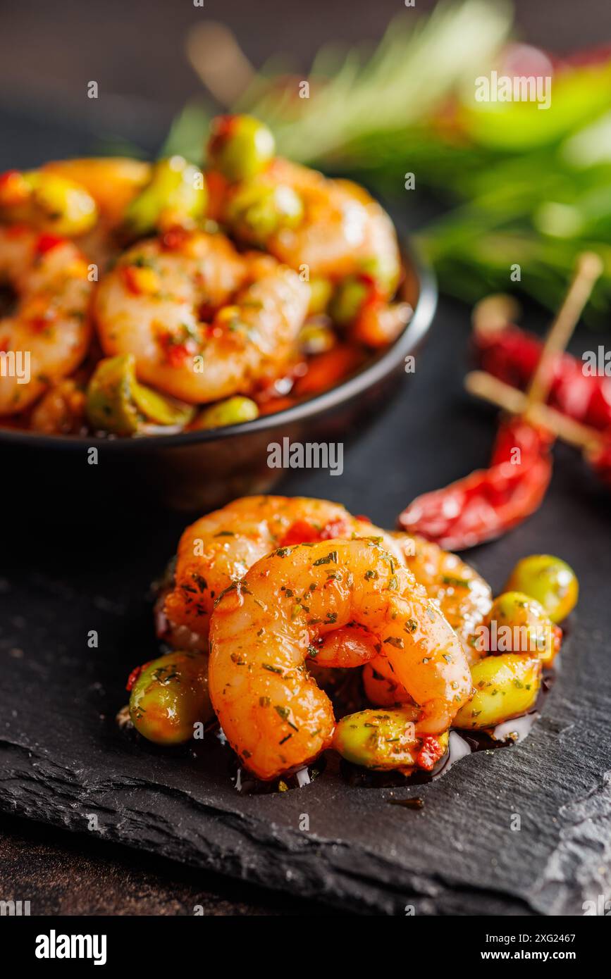 Salade fraîche avec crevettes et soja edamame sur une planche à découper noire. Banque D'Images