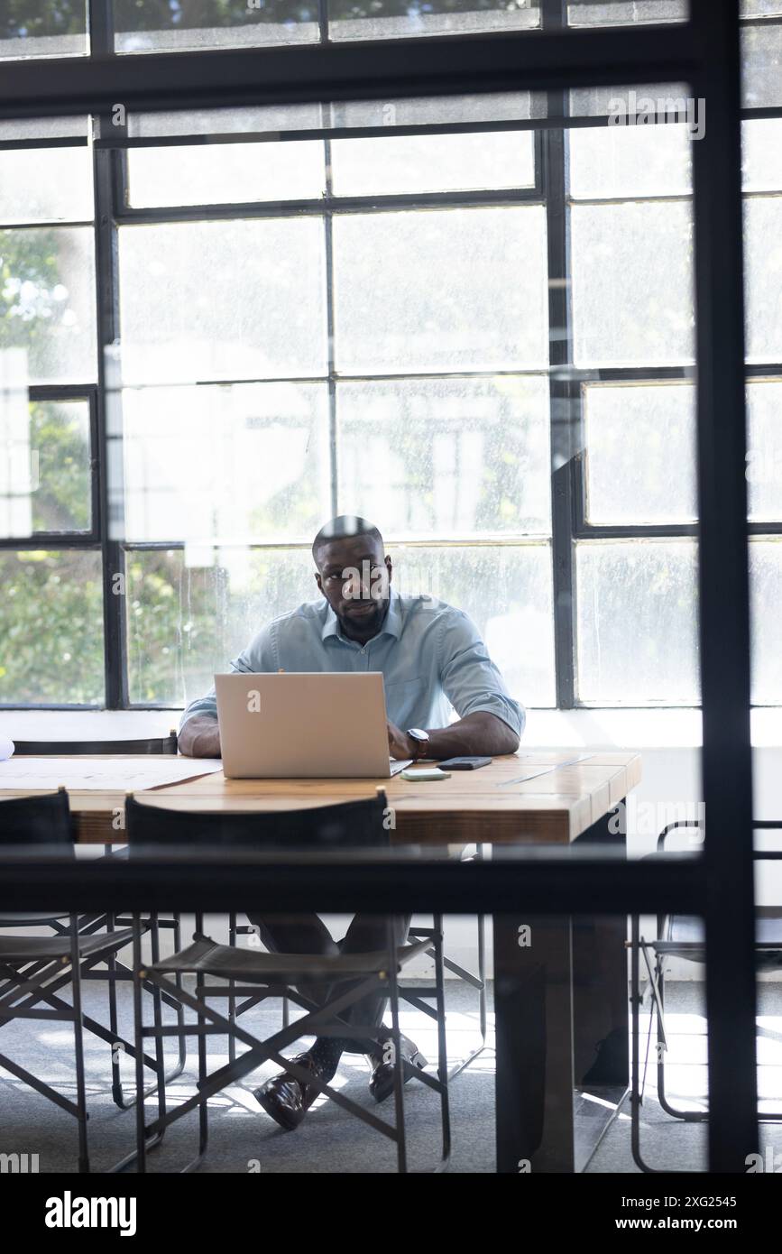 Travailler sur ordinateur portable, homme d'affaires assis au bureau dans un espace de bureau moderne, espace de copie Banque D'Images