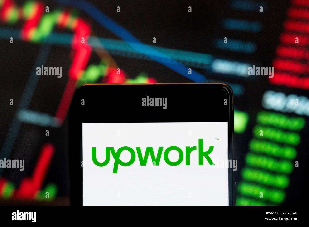 Dans cette illustration photo, la plateforme d’emplois freelance américaine, Upwork (NASDAQ : UPWK), logo vu affiché sur un smartphone avec un graphique d’indice boursier économique en arrière-plan. Banque D'Images