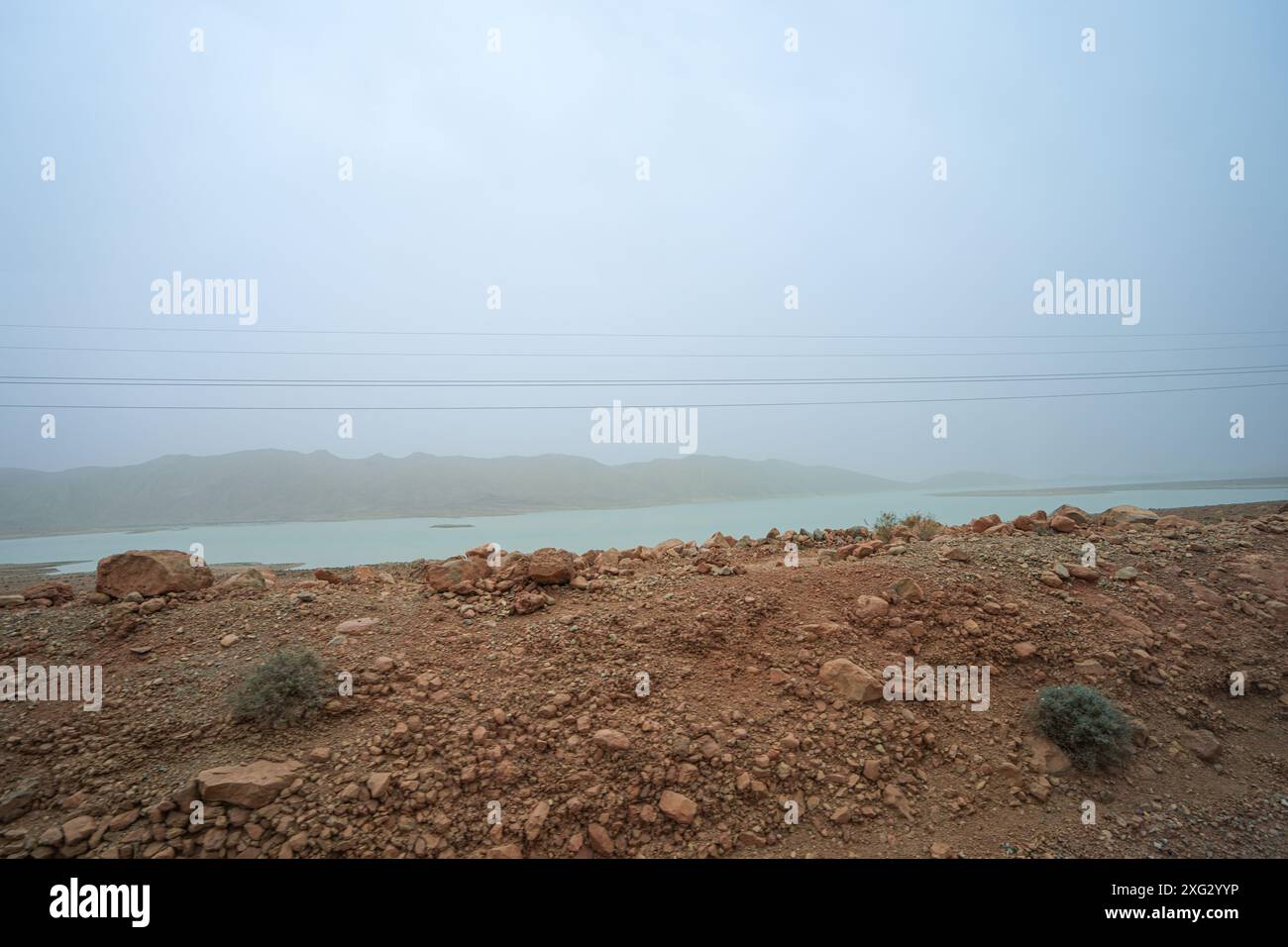 Vue panoramique sur le barrage Al Wahda, avec ses imposantes lignes électriques et sa végétation clairsemée. Barrage Al Wahda, rivière Ourgaha, Maroc. Banque D'Images