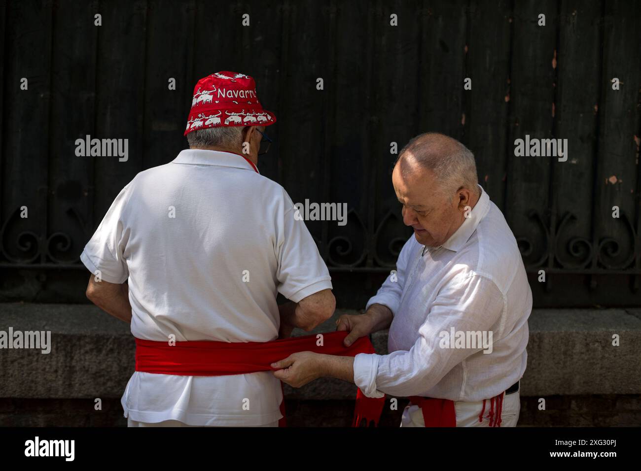 Madrid, Madrid, Espagne. 6 juillet 2024. Un homme aide son partenaire à ajuster sa ceinture rouge, lors de la célébration du début des festivités de San Fermin dans la paroisse de San Fermin de los Navarros à Madrid. La communauté Navarros de Madrid célèbre les festivités de San Fermin avec un lancement de fusée ''Chupinazo'' qui commence les festivités et ajoute ainsi à la grande célébration à Pampelune Espagne. (Crédit image : © Luis Soto/ZUMA Press Wire) USAGE ÉDITORIAL SEULEMENT! Non destiné à UN USAGE commercial ! Banque D'Images