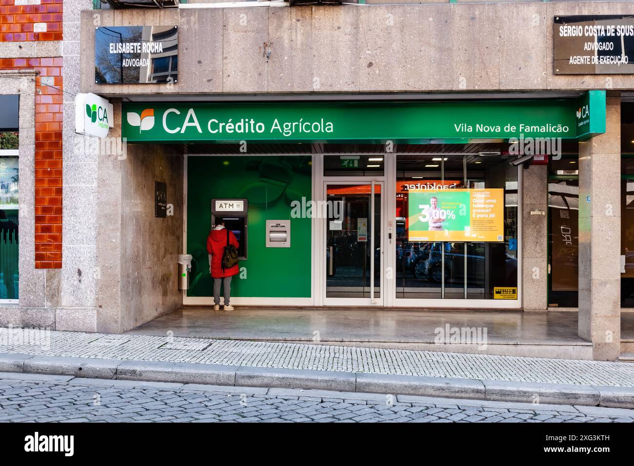 Vila Nova de Famalicao, Portugal : agence bancaire Credito Agricola. Client utilisant le Multibanco aka ATM, sur une agence bancaire Credito Agricola Banque D'Images