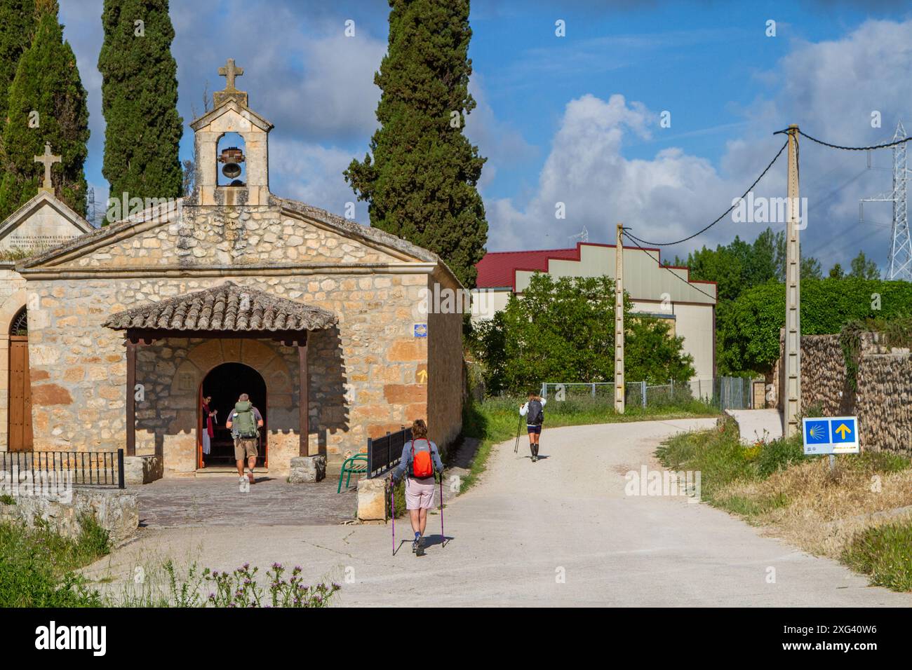 Pèlerins marchant le Camino de Santiago en passant devant l'ermitage de notre-Dame du Monastère dans le village Rabé de las Calzadas dans la province de Burgos Banque D'Images Pèlerins marchant le Camino de Santiago en passant devant l'ermitage de notre-Dame du Monastère dans le village Rabé de las Calzadas dans la province de Burgos Banque D'Images