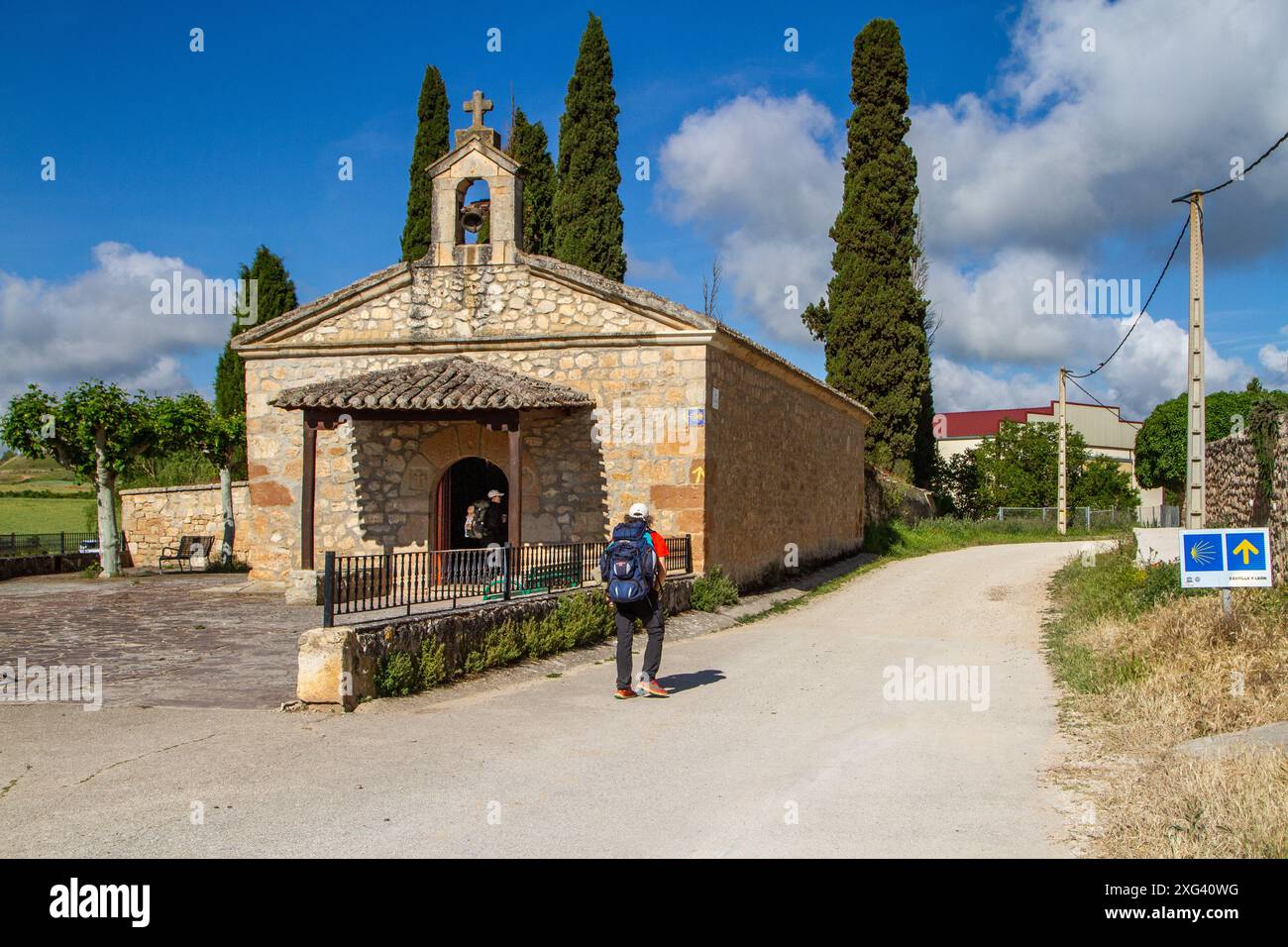 Pèlerins marchant le Camino de Santiago en passant devant l'ermitage de notre-Dame du Monastère dans le village Rabé de las Calzadas dans la province de Burgos Banque D'Images Pèlerins marchant le Camino de Santiago en passant devant l'ermitage de notre-Dame du Monastère dans le village Rabé de las Calzadas dans la province de Burgos Banque D'Images