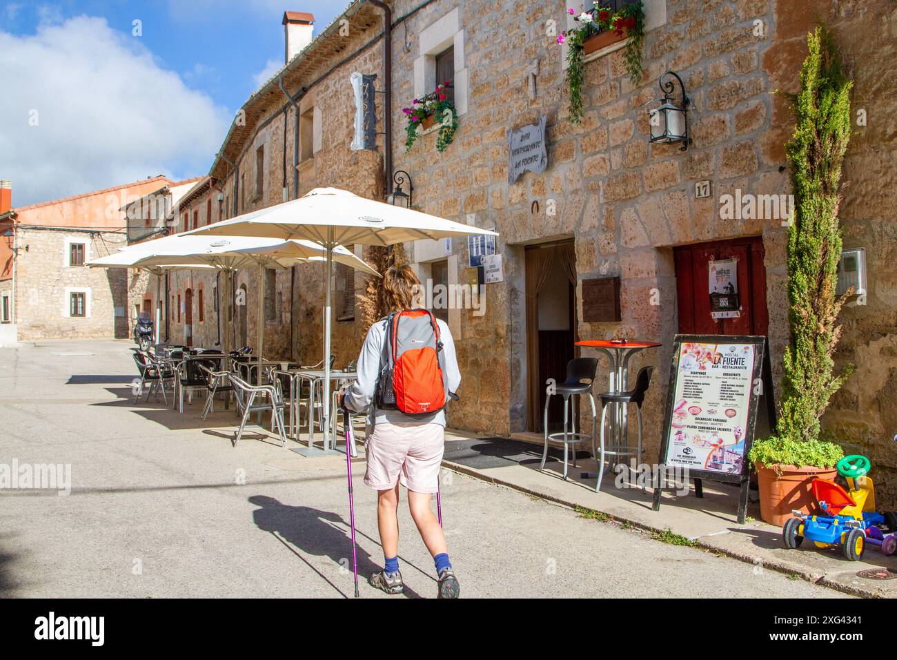 Pèlerins marchant sur le Camino de Santiago le chemin de Saint James route de pèlerinage à travers le village espagnol de Camino Rabe de las Calzadas, Castille León Banque D'Images