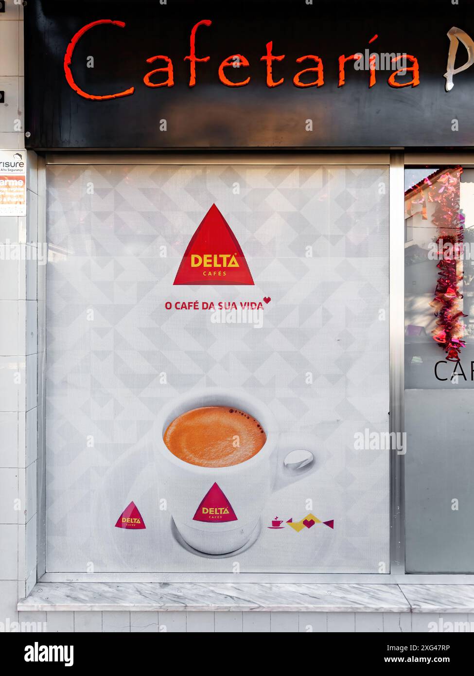 Famalicao, Portugal : publicité pour café expresso Delta cafés sur la fenêtre avant du magasin d'une cafétéria de café. La plus grande marque de café portugais Banque D'Images