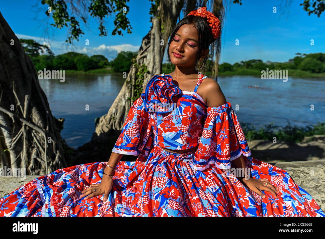 Dancers in Mompox présentent leur tenue folklorique traditionnelle vibrante, avec des jupes colorées, des chemisiers brodés et des accessoires complexes. Leurs mouvements gracieux et leurs performances animées mettent en valeur le riche patrimoine culturel et l’esprit festif de la région. L'emblématique rivière Magdalena en toile de fond. Banque D'Images