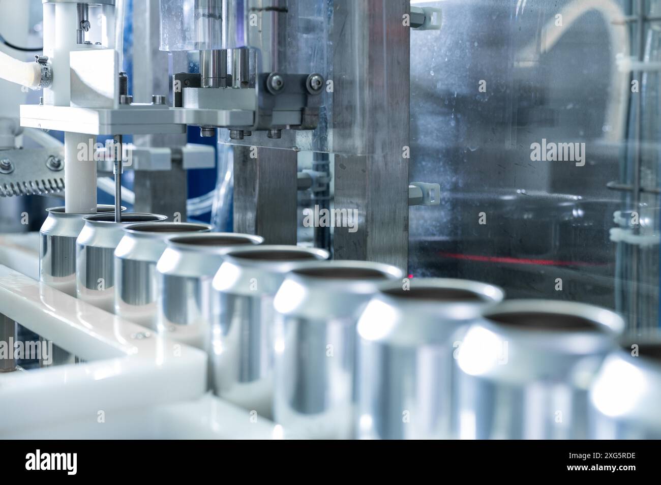 Videz de nouvelles boîtes en aluminium pour le processus de boisson dans la ligne d'usine sur la machine à bande transporteuse lors de la fabrication de boissons. secteur industriel de l'alimentation et des boissons Banque D'Images