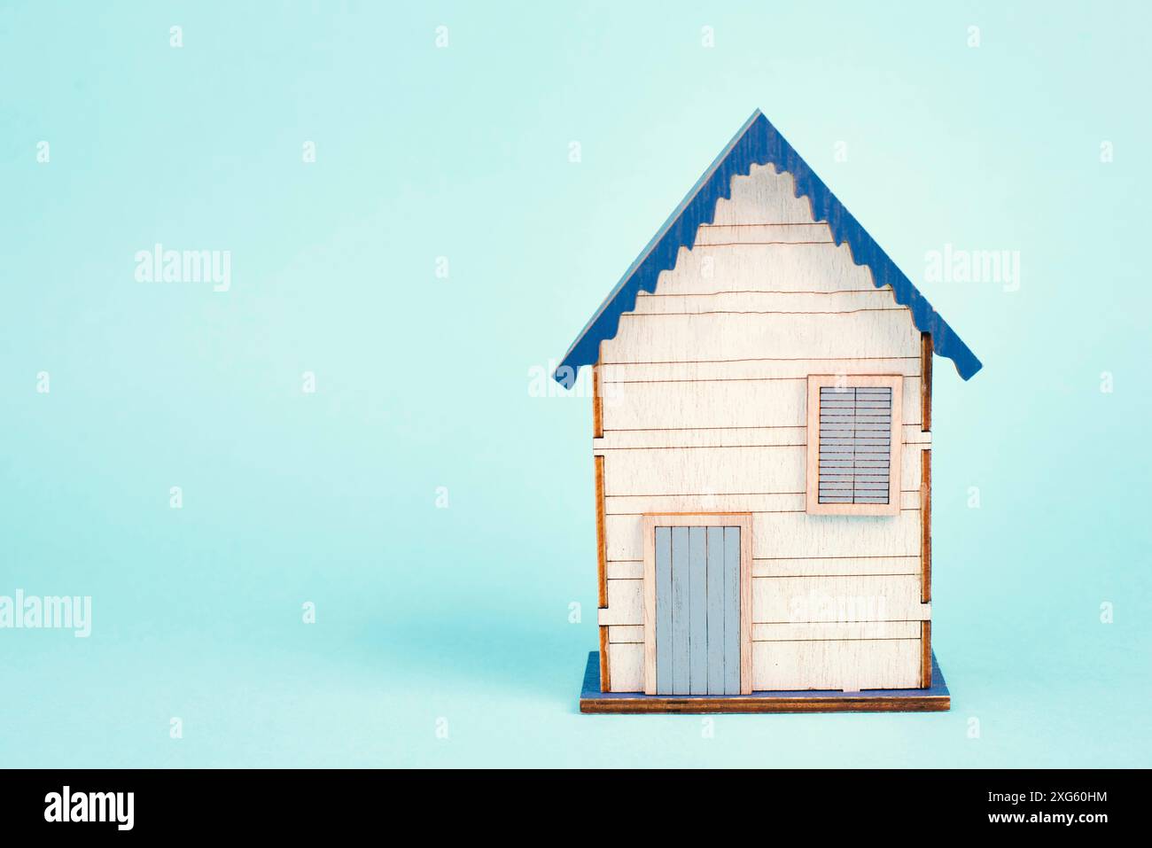 Maison en bois, fond bleu, achat ou location d'une maison, concept immobilier, réservation de maison pour vacances, espace de copie pour texte Banque D'Images