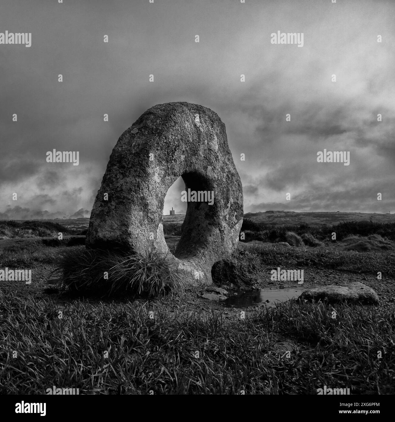 Une vue de la lande de Cornouailles de la pierre trouée de Mên-an-Tol, avec Greenburrow Engine House au centre du trou au loin. Banque D'Images