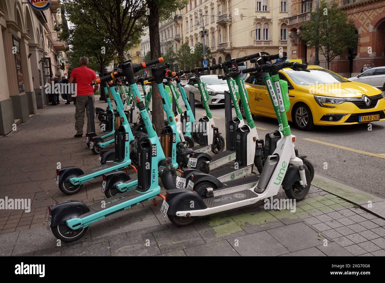 Scooters électriques des systèmes Lime et Tier Sharing garés sur le trottoir à Budapest, Hongrie Banque D'Images