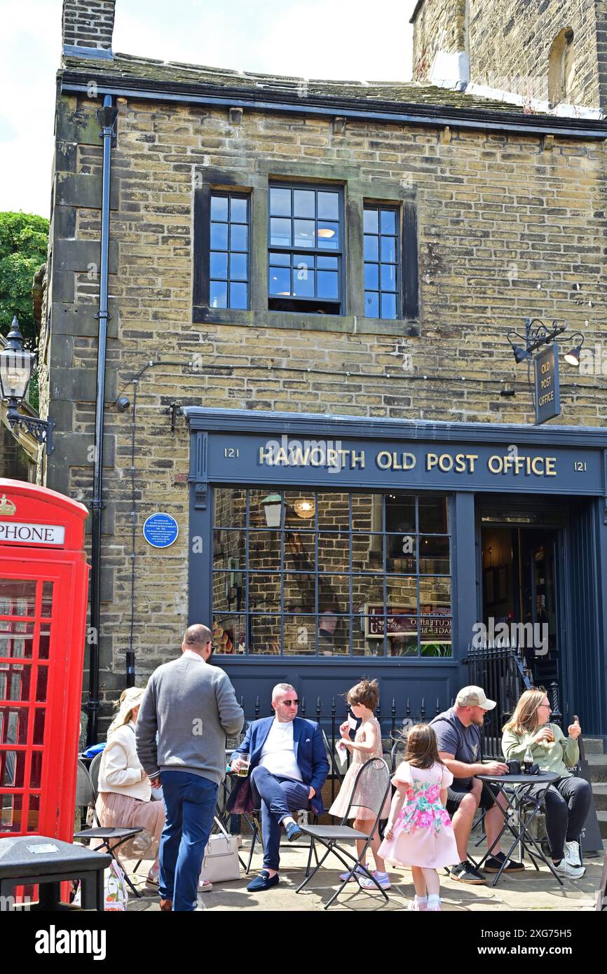 Les gens étaient assis devant le café Old Post Office à Haworth, West Yorkshire Banque D'Images