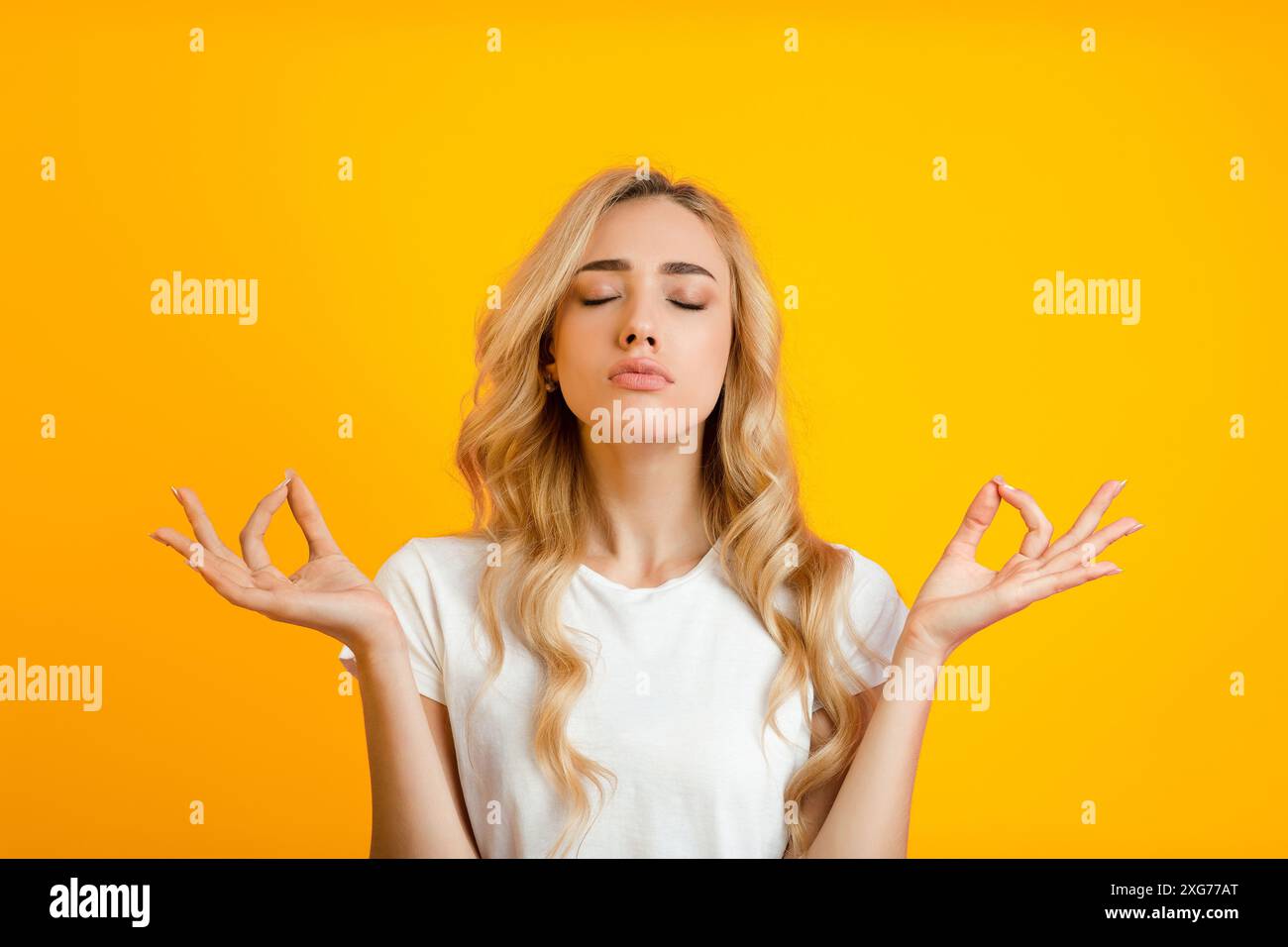 Jeune femme pratiquant la méditation avec les yeux fermés Banque D'Images
