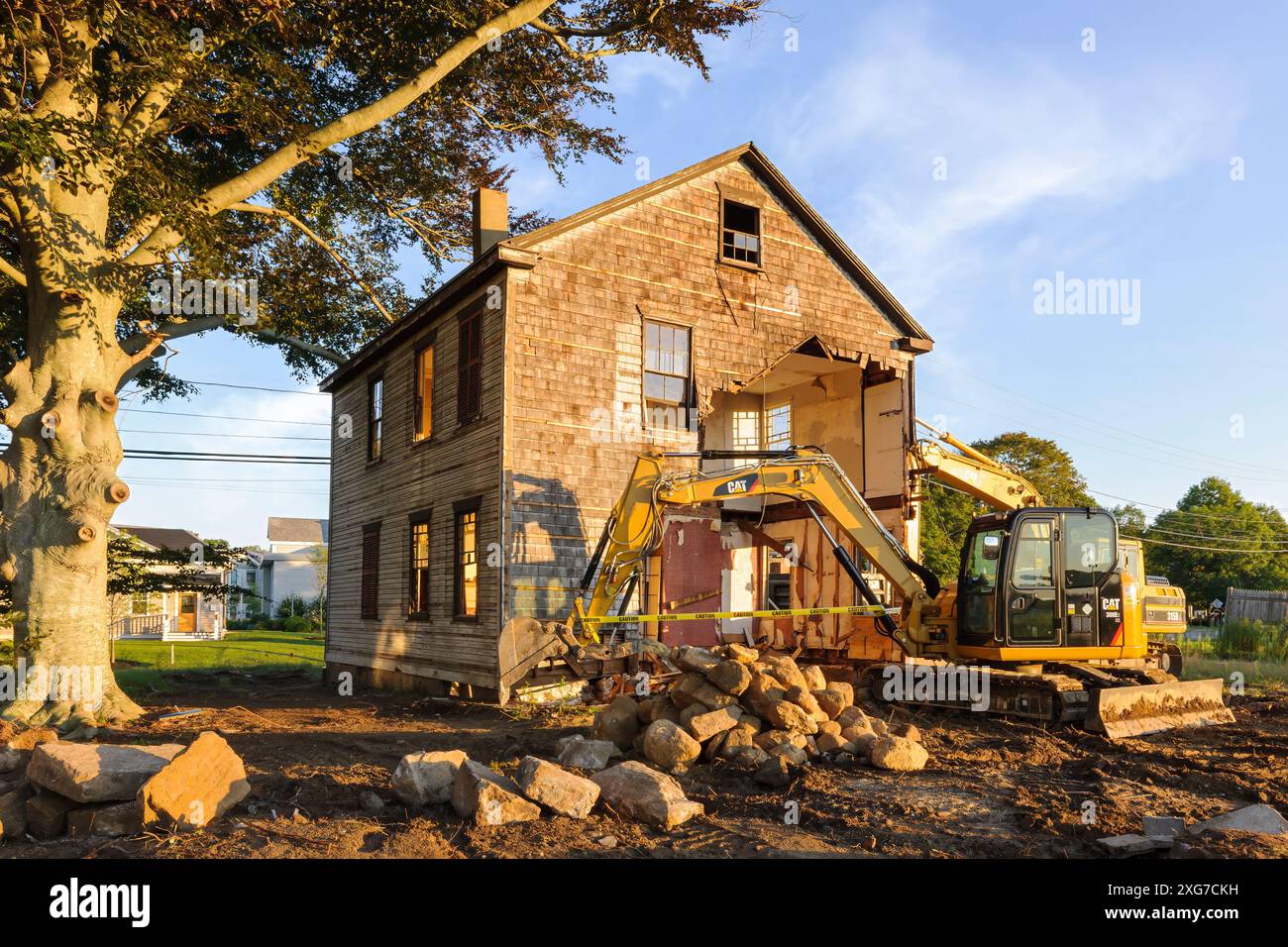 Plymouth, Massachusetts, États-Unis - le matériel d'excavation s'aligne à côté d'une vieille maison dans le Massachusetts alors que les entrepreneurs se préparent à la démolition. Banque D'Images