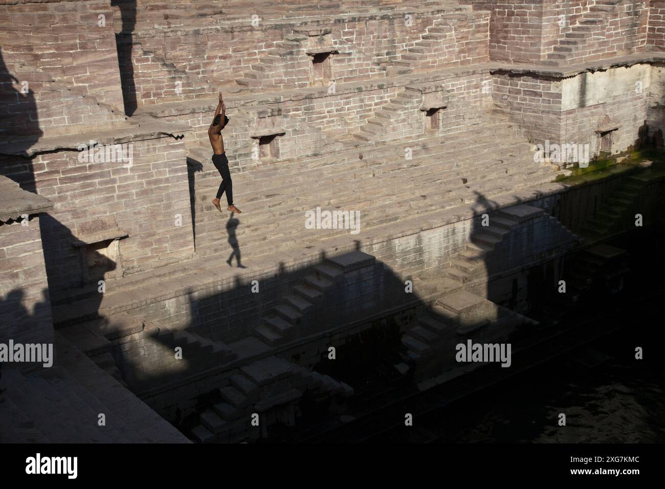 Jeune homme sautant dans le stepwell des Toorji (Toorji Ka Jhalra), Jodpur, Inde. Construit dans les années 1740 par le Consort du Maharaja Abhay Singh. Banque D'Images