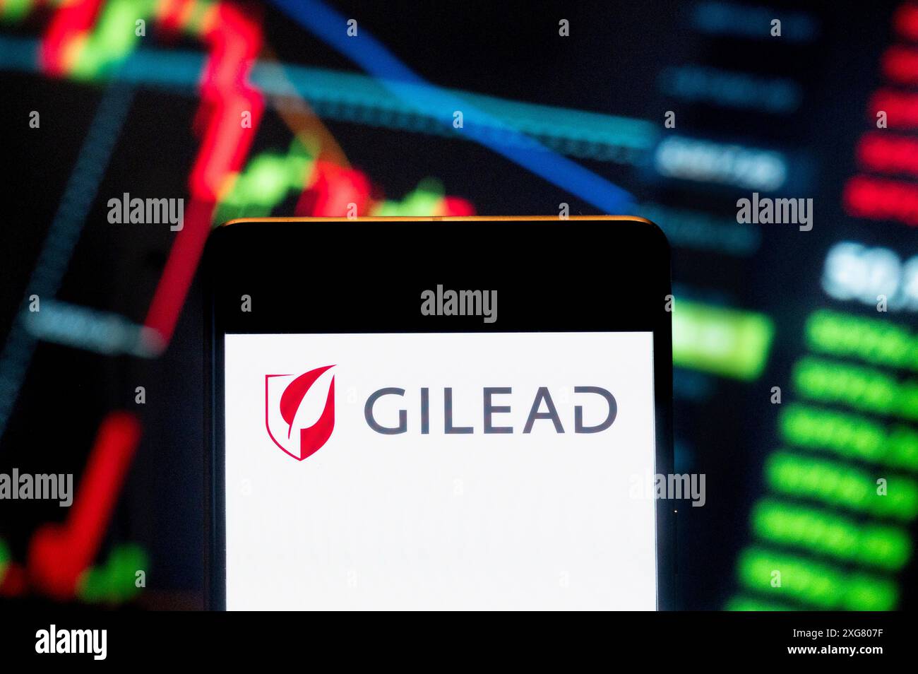 Dans cette illustration photo, le logo de la société américaine de biotechnologie Gilead Sciences (NASDAQ : GILD) est affiché sur un smartphone avec un graphique de l'indice boursier économique en arrière-plan. Banque D'Images