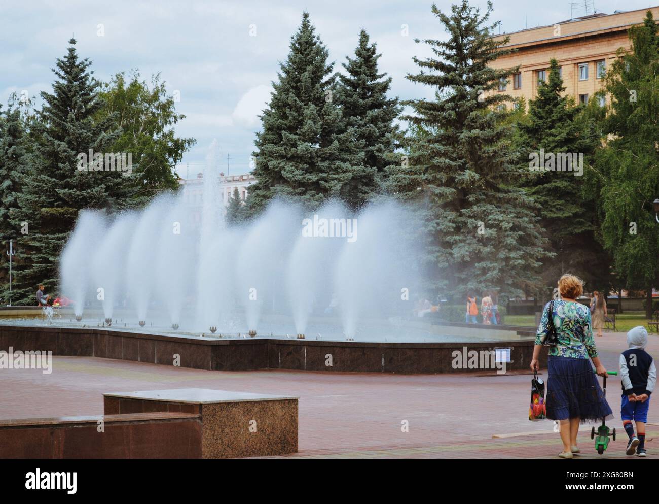 Tcheliabinsk Russie - 2 juillet 2015, un jardin public dans le centre de Tcheliabinsk. Une femme marche avec un enfant à la fontaine Banque D'Images