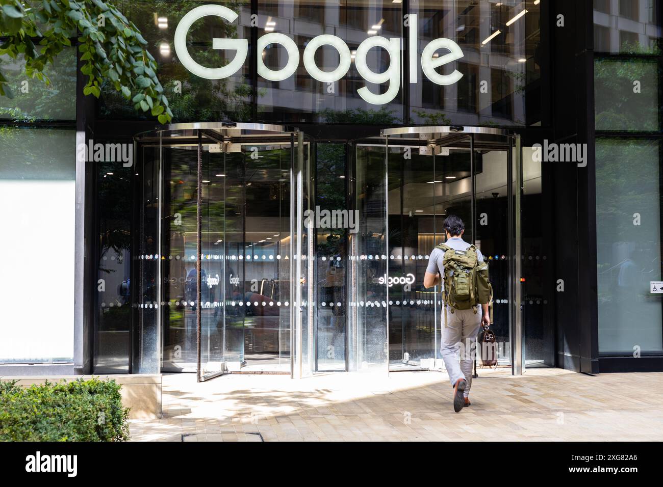 Un gros plan de l'homme marchant dans l'entrée de Google London HQ 6 Pancras Sq Londres Angleterre Royaume-Uni Banque D'Images