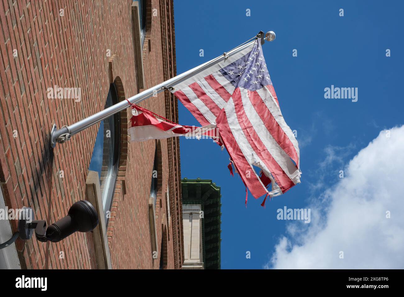 Un drapeau américain en lambeaux volant devant le bureau de poste américain à Flint Michigan USA Banque D'Images