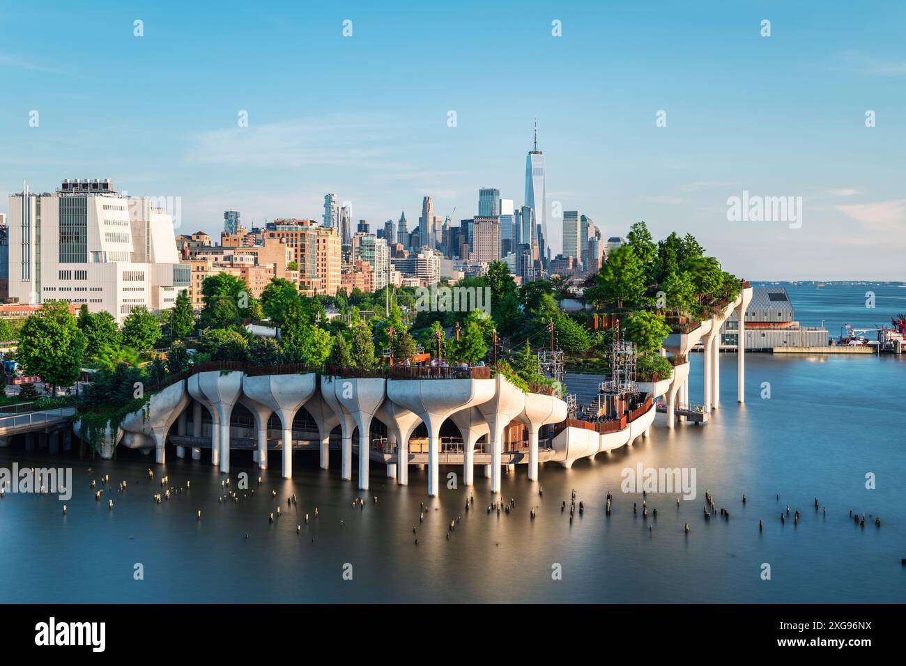 Longue exposition de Little Island au-dessus de la rivière Hudson à Chelsea, New York, avec la ligne d'horizon inférieure de Manhattan comme toile de fond magnifique au crépuscule. Banque D'Images