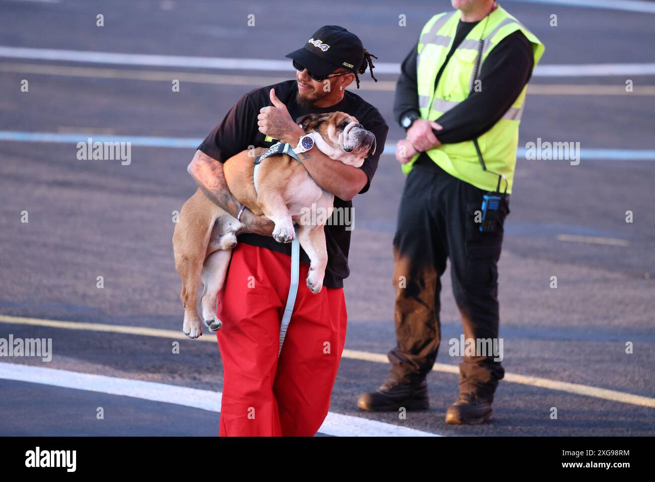 Londres 7 juillet 2024 après avoir remporté le 9ème Grand Prix de Silverstone de Grande-Bretagne , Lewis Hamilton a fait un retour élégant à Londres en hélicoptère , accompagné de son cher Buldog anglais Rosco. La star de la formule 1 a été vue portant son animal de compagnie bien-aimé alors qu'il marchait vers le terminal , montrant leur lien étroit. La joie de Hamilton était évidente. Banque D'Images