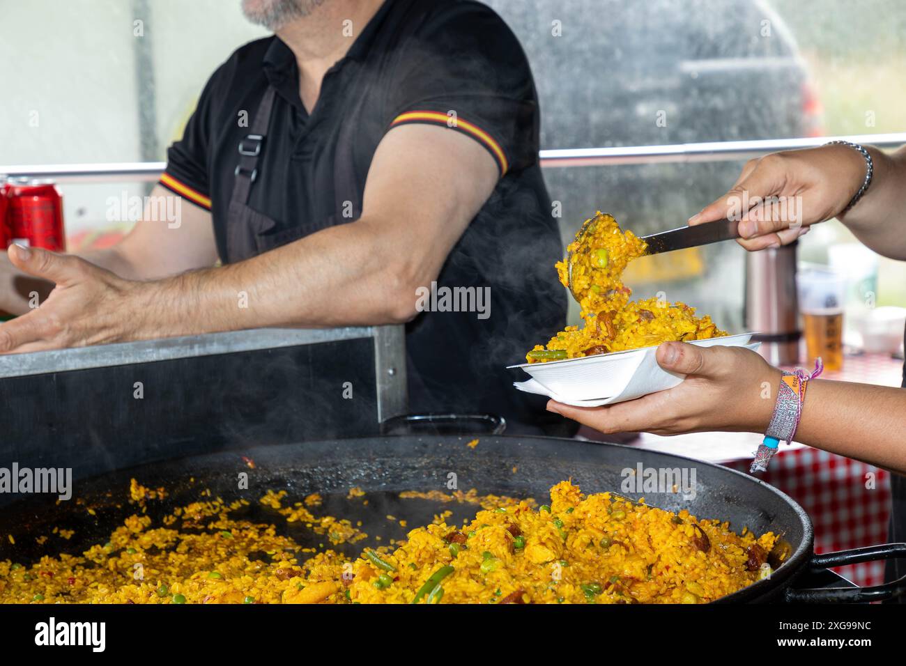 Négociant au Stockton Heath Festival 2024 vendant de la paella à partir de casseroles géantes Banque D'Images