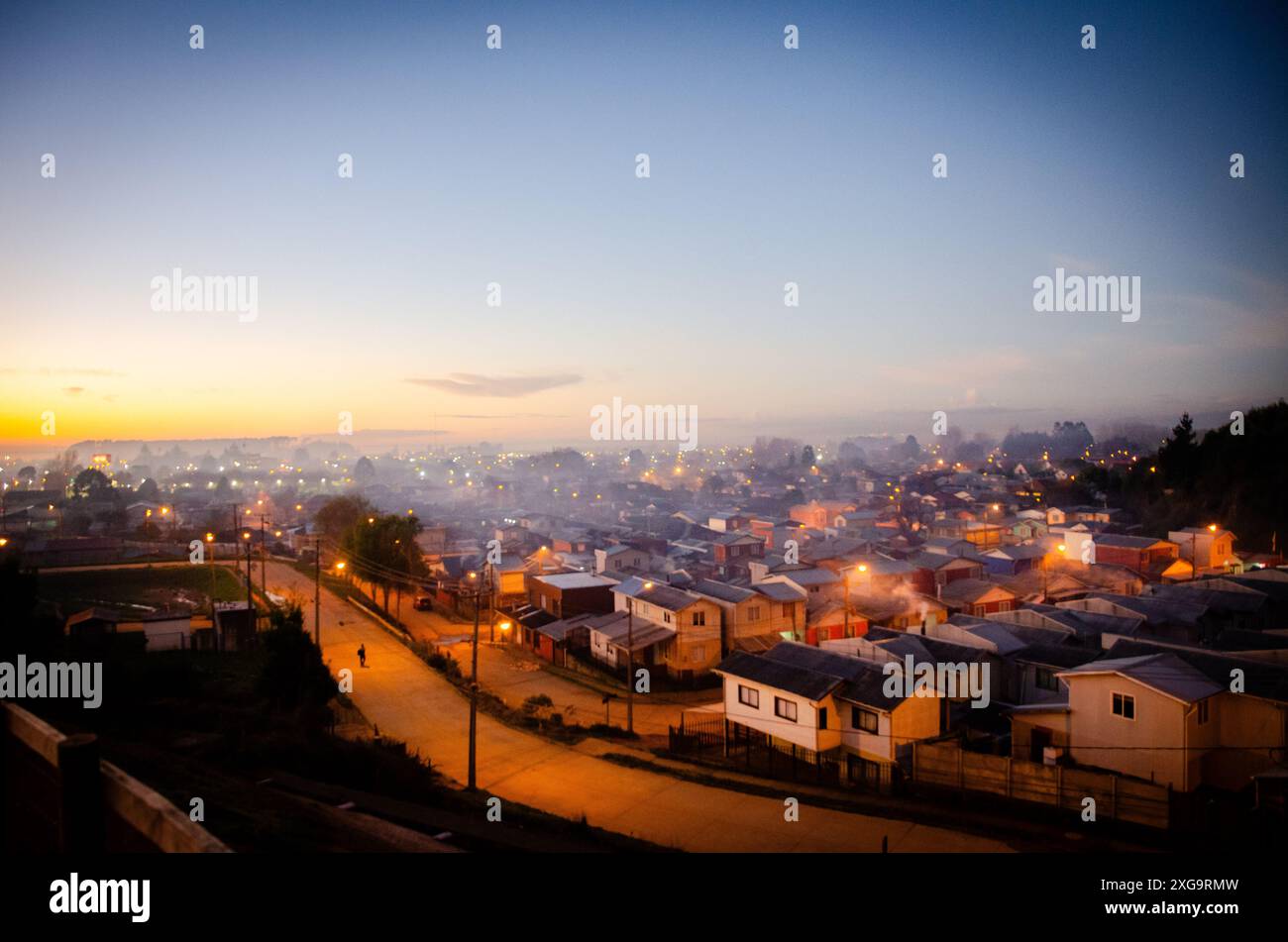 Ciel brumeux dans un quartier résidentiel de la ville d'Arauco lors d'un coucher de soleil d'automne, Biobío, Chili Banque D'Images