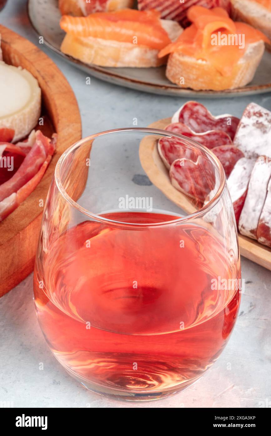 Vin de rose avec sandwichs au jambon, au fromage et au saumon. Tapas espagnoles dans un bar. Partage de nourriture. En-cas méditerranéens Banque D'Images