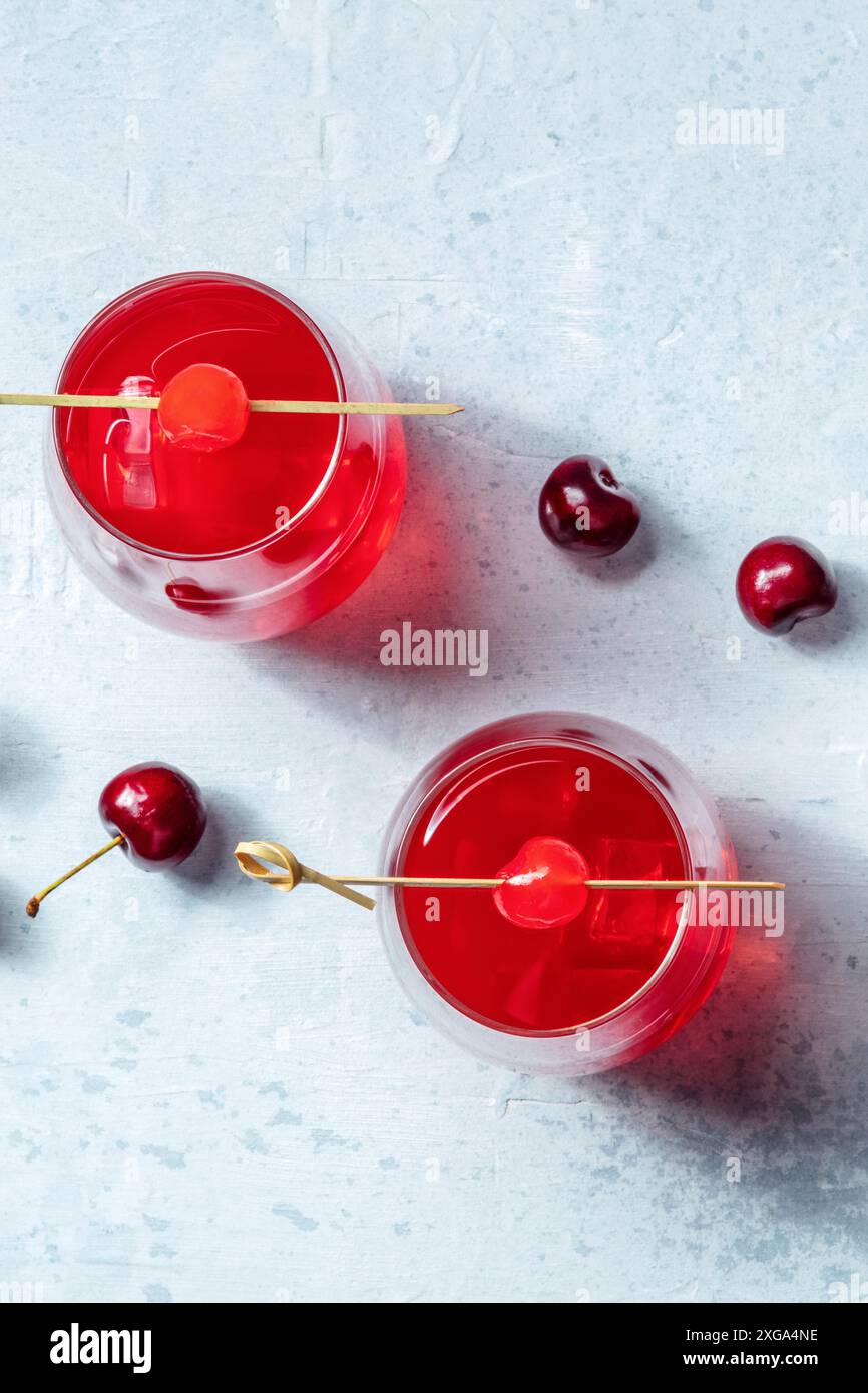 Cocktail cerise et une queue de mocktail, une boisson rouge vibrante avec glace, avec un endroit pour le texte Banque D'Images