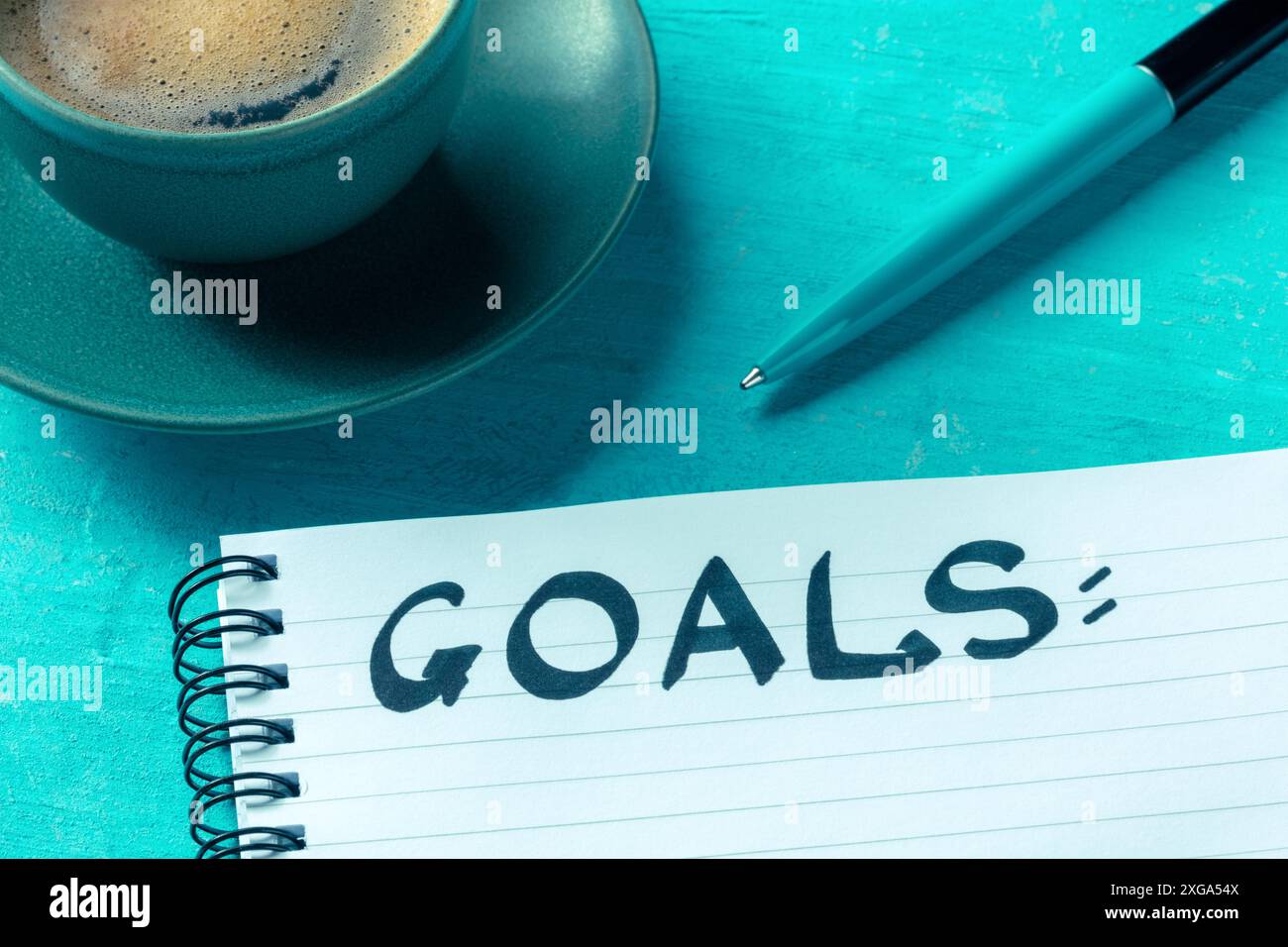 Panorama des objectifs. Le concept de définition d'objectifs, d'écriture d'une liste ou d'un plan. Un bloc-notes en papier avec un stylo et le mot manuscrit, avec une tasse de café dessus Banque D'Images