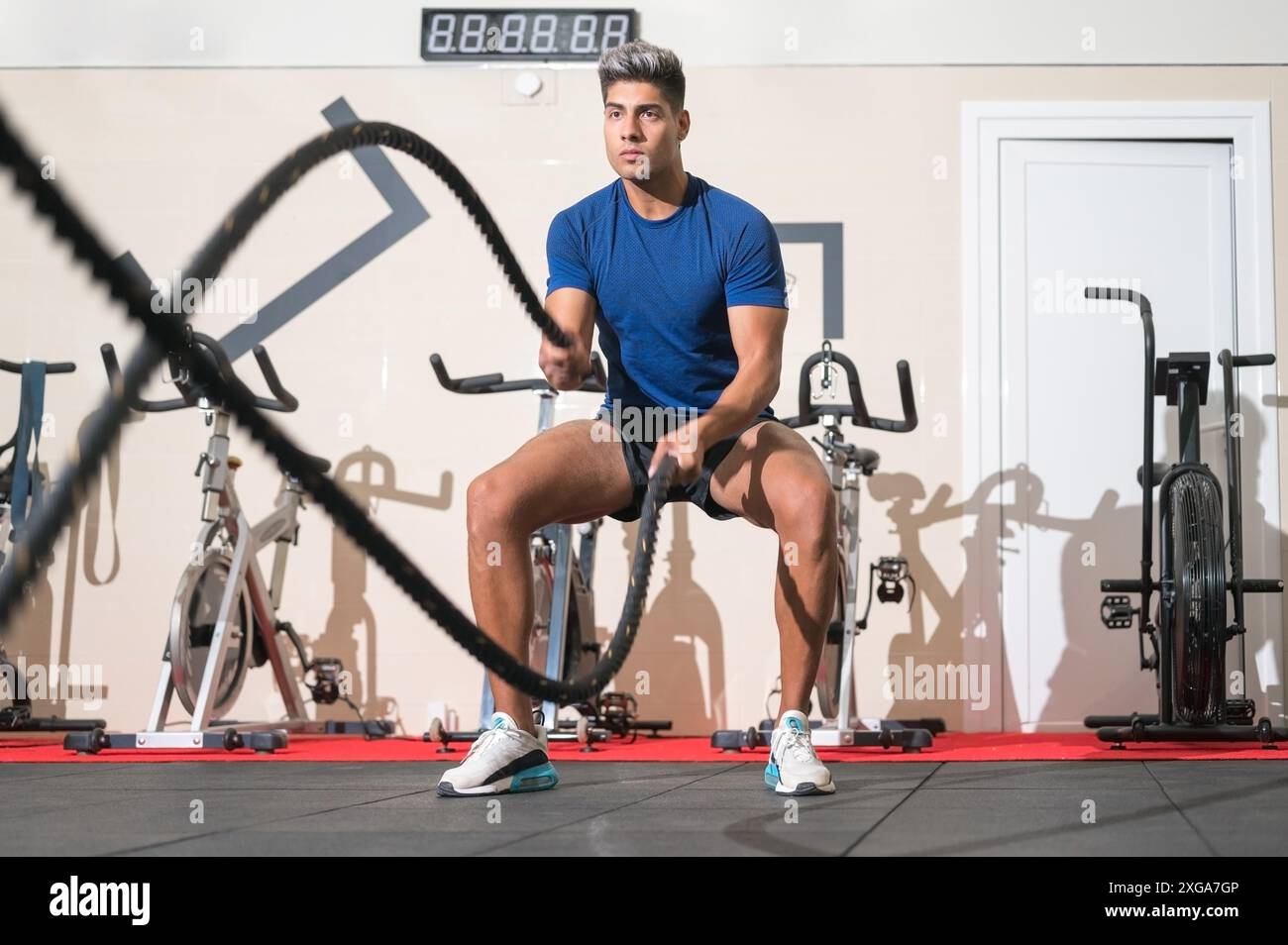Homme s'entraînant avec de la corde dans un gymnase de fitness d'entraînement fonctionnel. Photo de haute qualité Banque D'Images