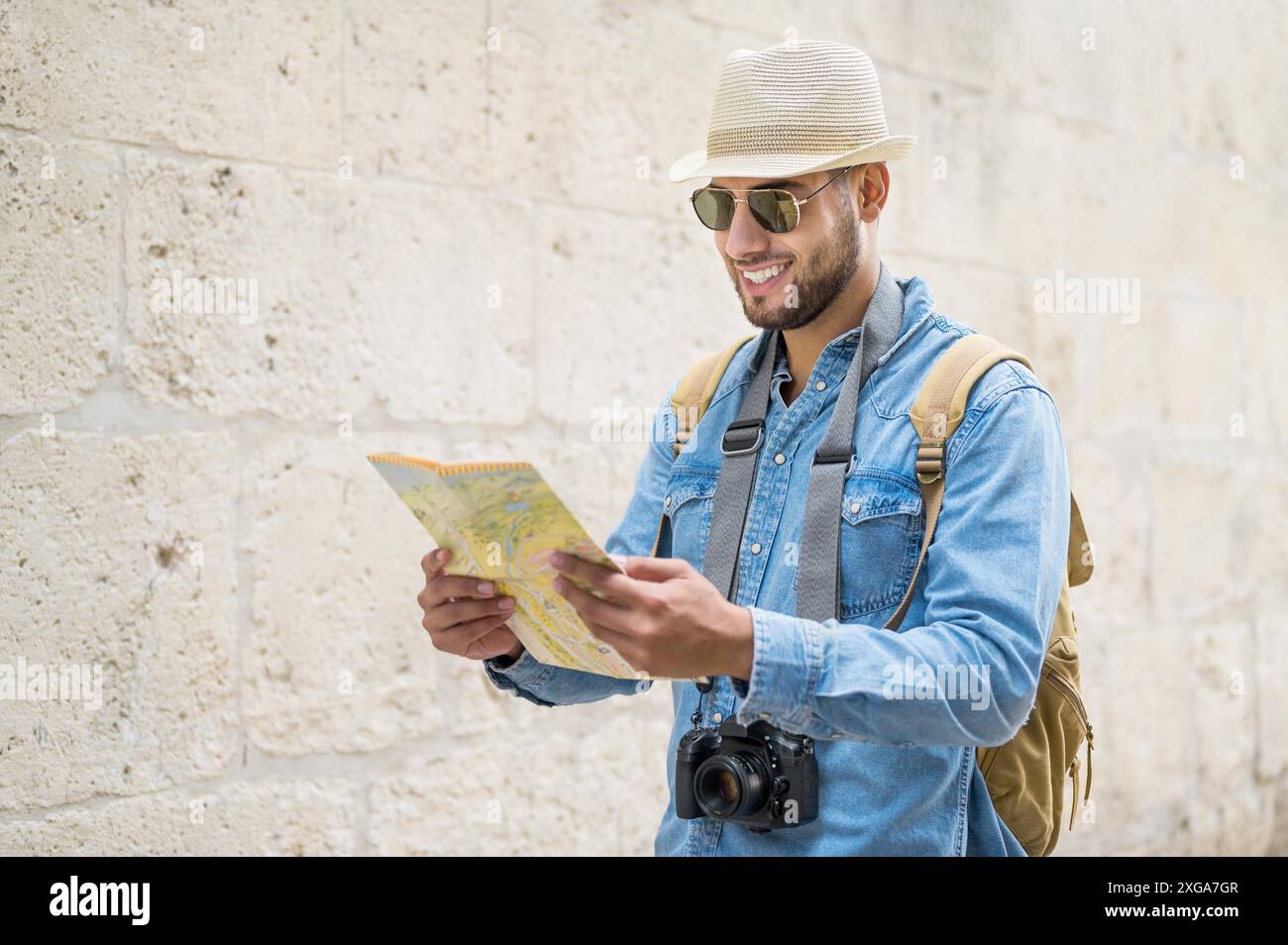 Jeune homme beau avec carte touristique regardant autour de la rue de la ville. Photo de haute qualité Banque D'Images