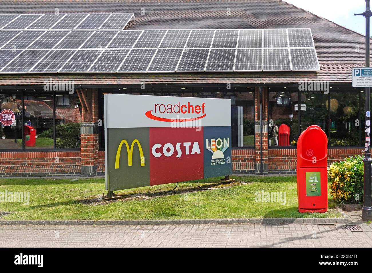 Autoroute M25 Clacket Lane Roadchef services signe et logos de marque de certaines entreprises dans la construction de panneaux solaires revêtus sur le toit journée ensoleillée dans le Surrey Angleterre Royaume-Uni Banque D'Images
