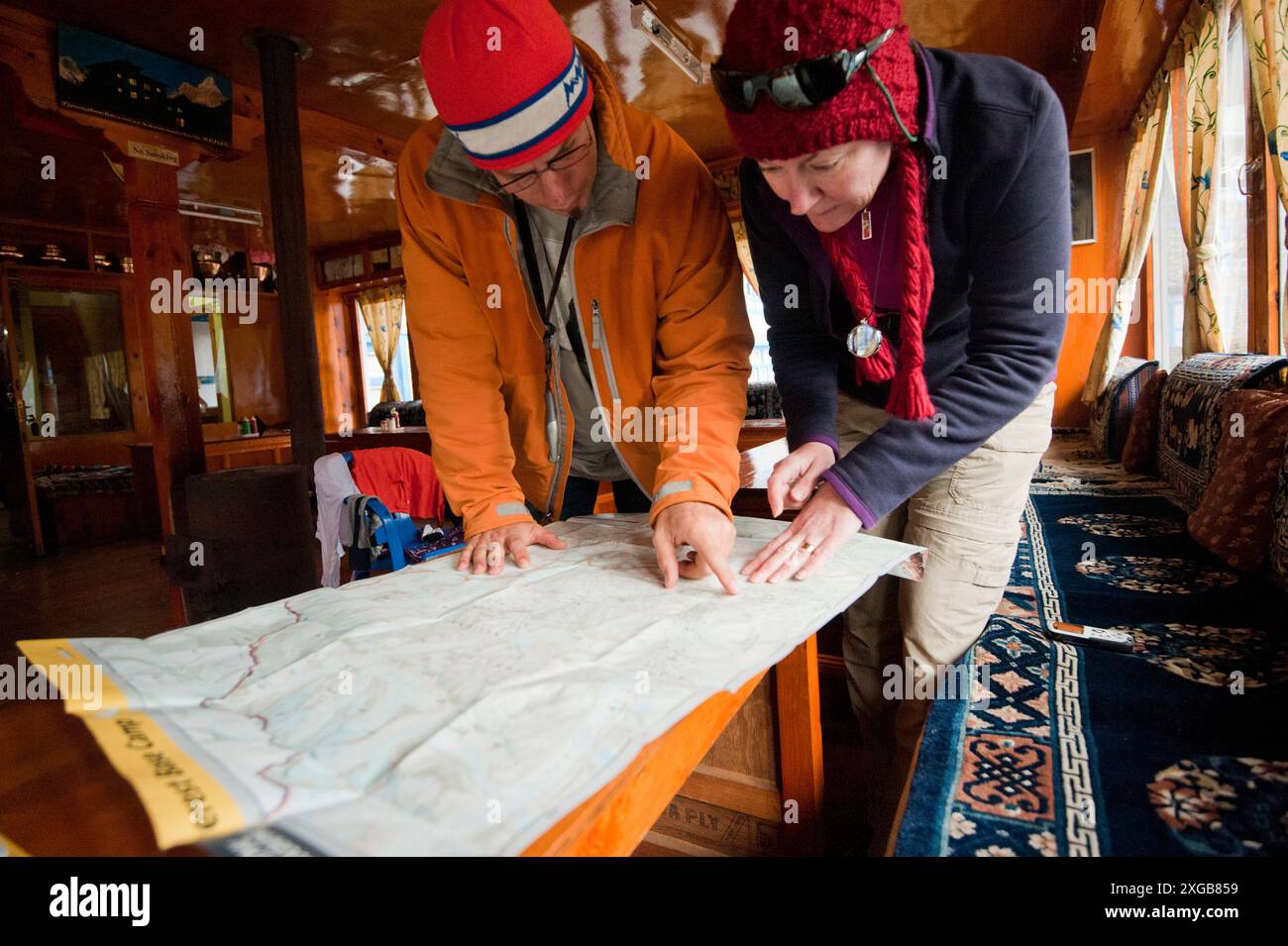 Un homme et une femme d'âge moyen regardent une carte du Mt. everest trek au camp de base dans la région de Khumbu au Népal dans leur auberge à Namche Bazaar. Banque D'Images Un homme et une femme d'âge moyen regardent une carte du Mt. everest trek au camp de base dans la région de Khumbu au Népal dans leur auberge à Namche Bazaar. Banque D'Images
