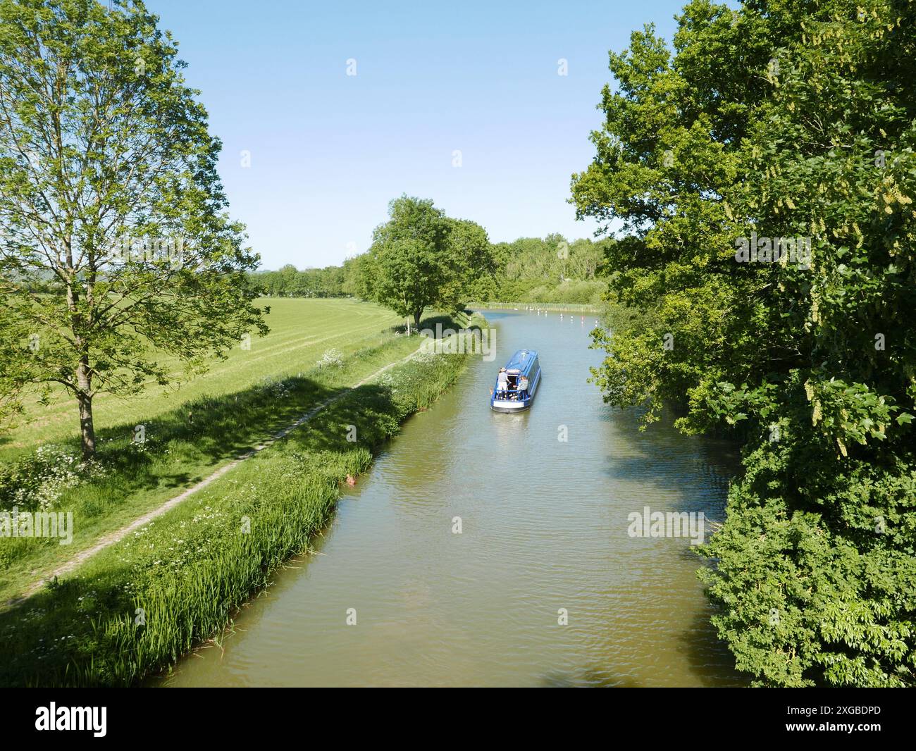 Vue depuis le Ladies Bridge du sentier de remorquage du canal Kennet et Avon près de Pewsey par une journée ensoleillée avec un barge sur la rivière Banque D'Images