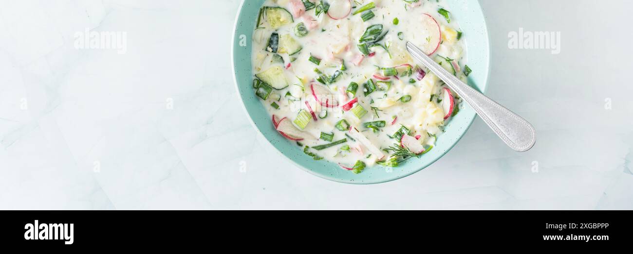 Soupe froide d'été Okroshka bannière, soupe avec légumes et saucisses, œufs et herbes fraîches et yaourt, soupe russe traditionnelle Banque D'Images