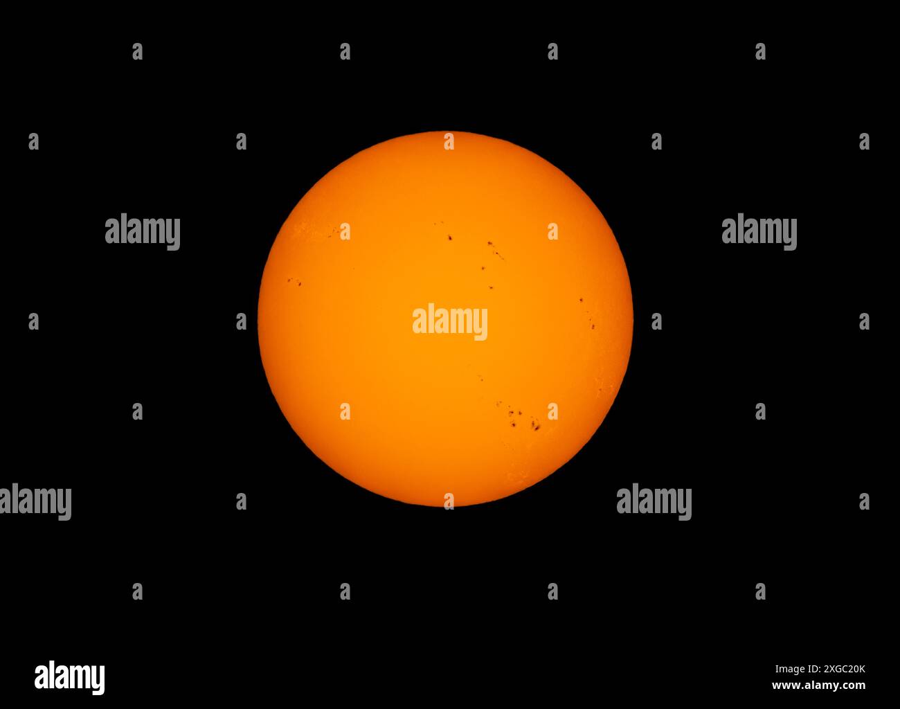 Le soleil de l'après-midi de couleur orange brille avec de nombreuses taches solaires utilisant un filtre solaire fait maison sur un fond noir. 22 avril 2024 Banque D'Images