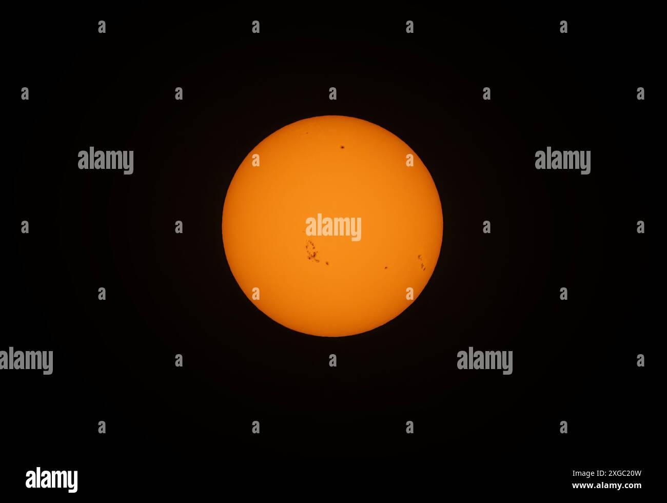 Le soleil de l'après-midi de couleur orange brille avec de nombreuses taches solaires utilisant un filtre solaire fait maison sur un fond noir. 7 mai 2024 Banque D'Images