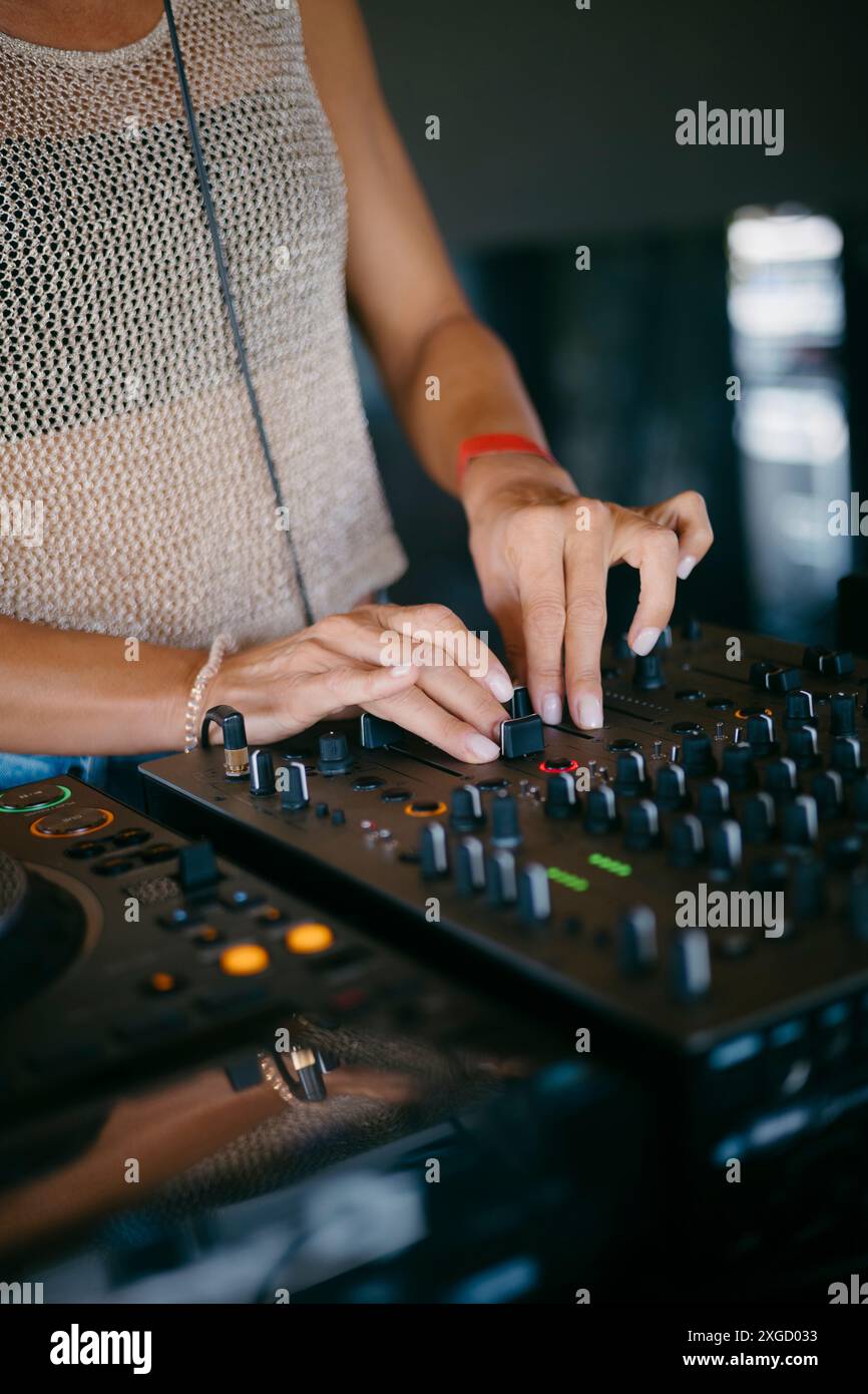 Femme DJ mains créer et réguler la musique sur console dj mixeur dans un festival de musique Banque D'Images