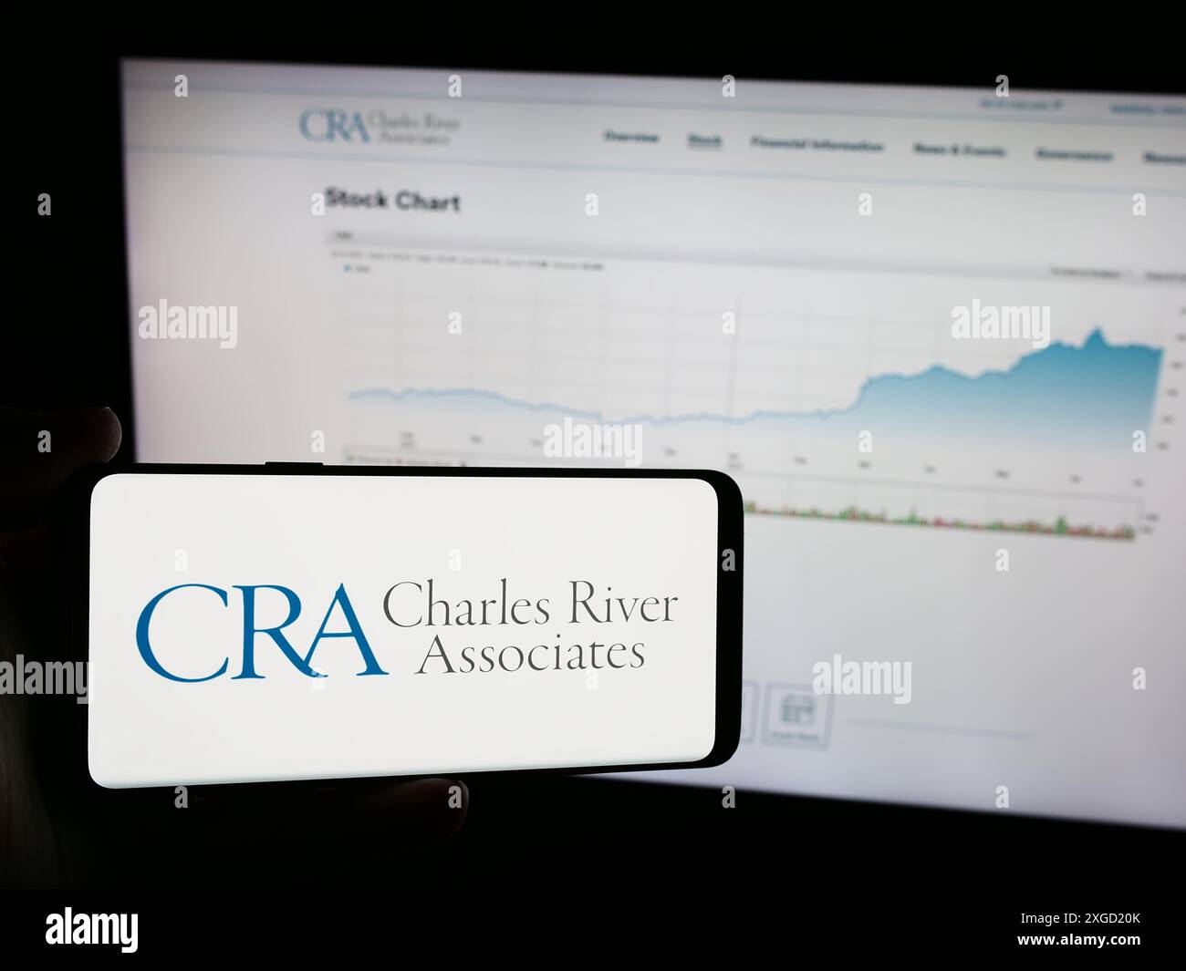 Personne tenant un téléphone portable avec le logo de CRA International Inc (Charles River Associates) devant la page Web de l'entreprise. Concentrez-vous sur l'affichage du téléphone. Banque D'Images
