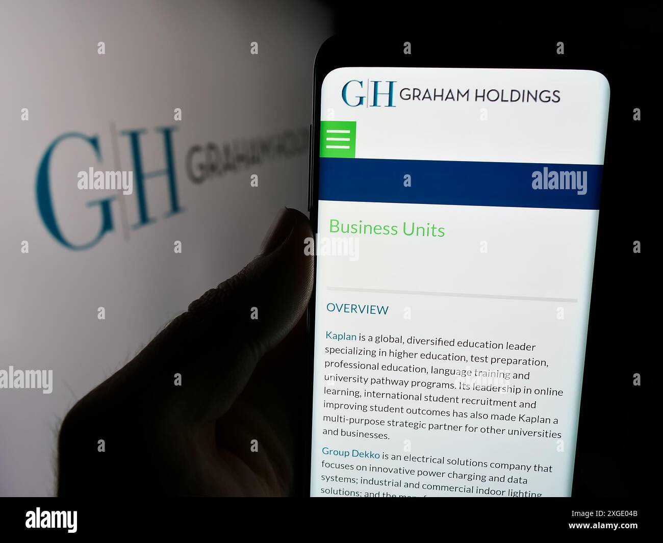 Personne tenant le téléphone portable avec la page Web de l'entreprise de médias américains Graham Holdings Company devant le logo de l'entreprise. Concentrez-vous sur le centre de l'écran du téléphone. Banque D'Images