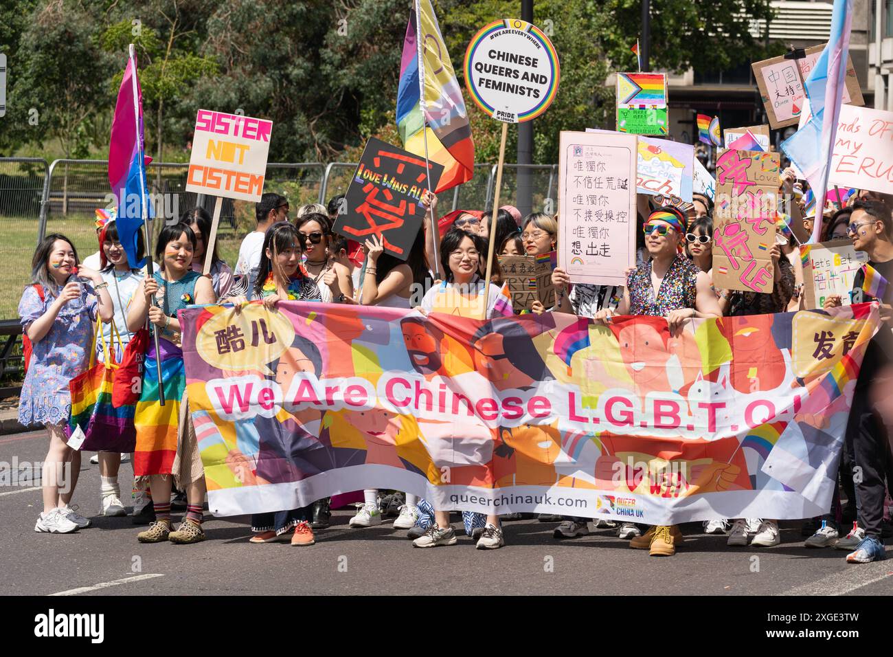 Un groupe de Chinois marchant à la London Pride 2024 portant une grande bannière qui dit "nous sommes des Chinois L.G.B.T.Q.I.A.+" et portant des panneaux en mandarin Banque D'Images