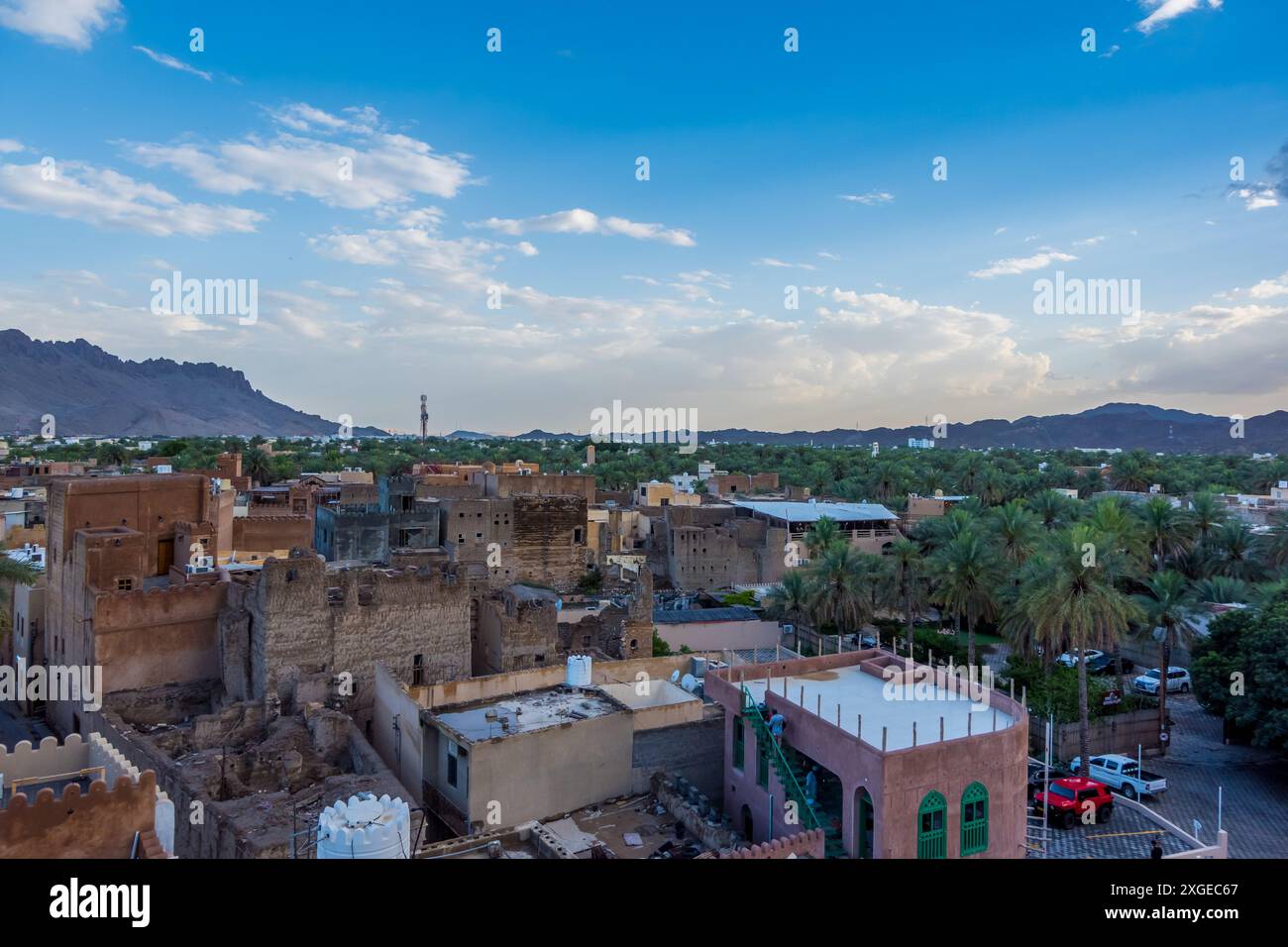 Belle vue sur le coucher du soleil de la vieille ville de Nizwa, Oman avec des ruines historiques et des bâtiments, y compris le fort de Nizwa Banque D'Images