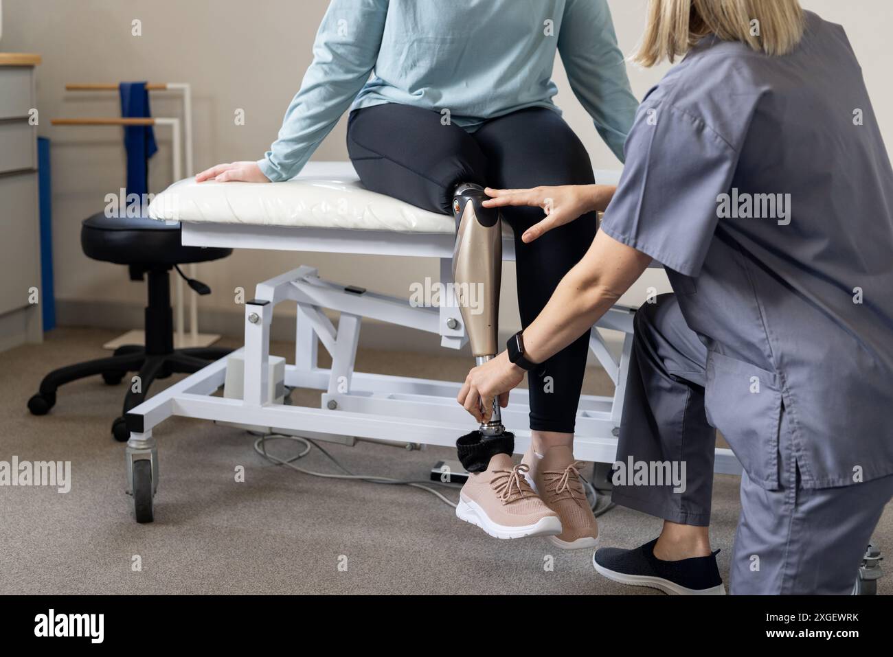 Ajustement de la jambe prothétique, professionnel de santé assistant le patient en clinique Banque D'Images