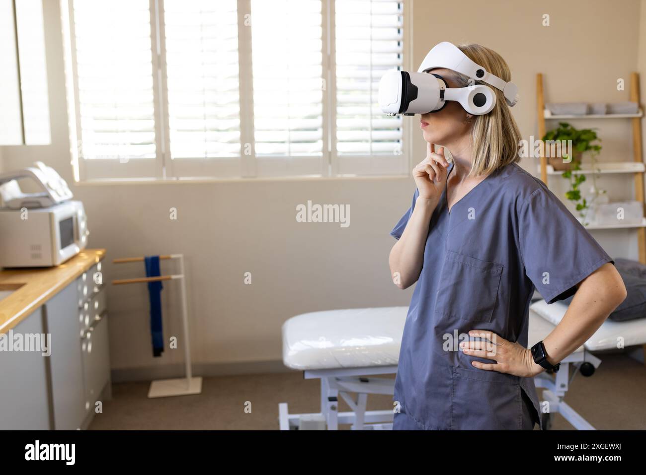 À l'aide d'un casque VR, femme dans les gommages explorant l'environnement virtuel dans une clinique médicale prothétique, copie s Banque D'Images