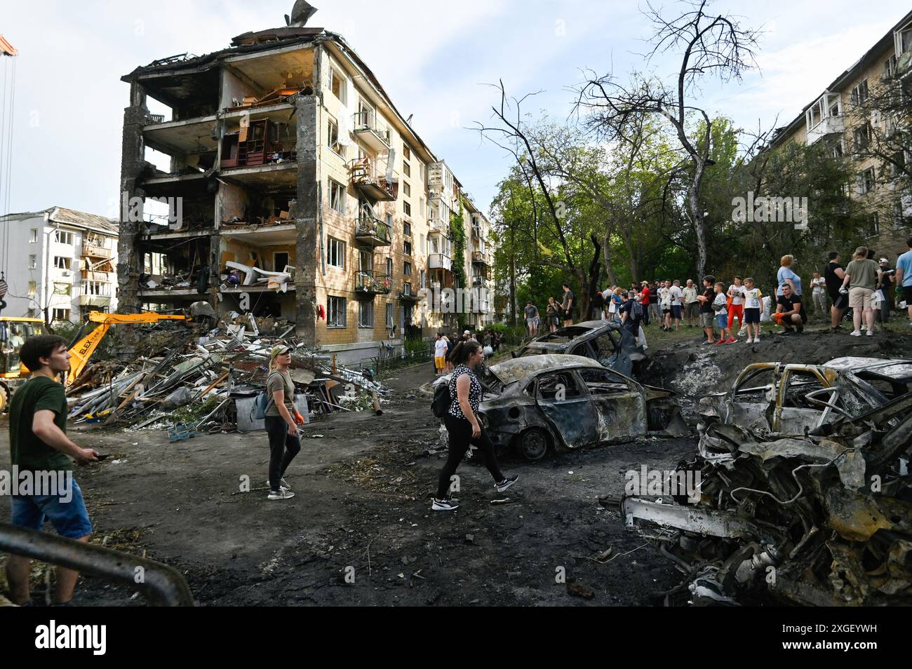 Kiev, Ukraine. 08 juillet 2024. Les gens passent devant les voitures brûlées qui se trouvent près du bâtiment résidentiel détruit à la suite d'une attaque à la roquette de l'armée russe à Kiev. À la suite de l'attaque massive de missiles de l'armée russe sur le territoire de l'Ukraine, 36 personnes ont été tuées et 140 blessées. Crédit : SOPA images Limited/Alamy Live News Banque D'Images