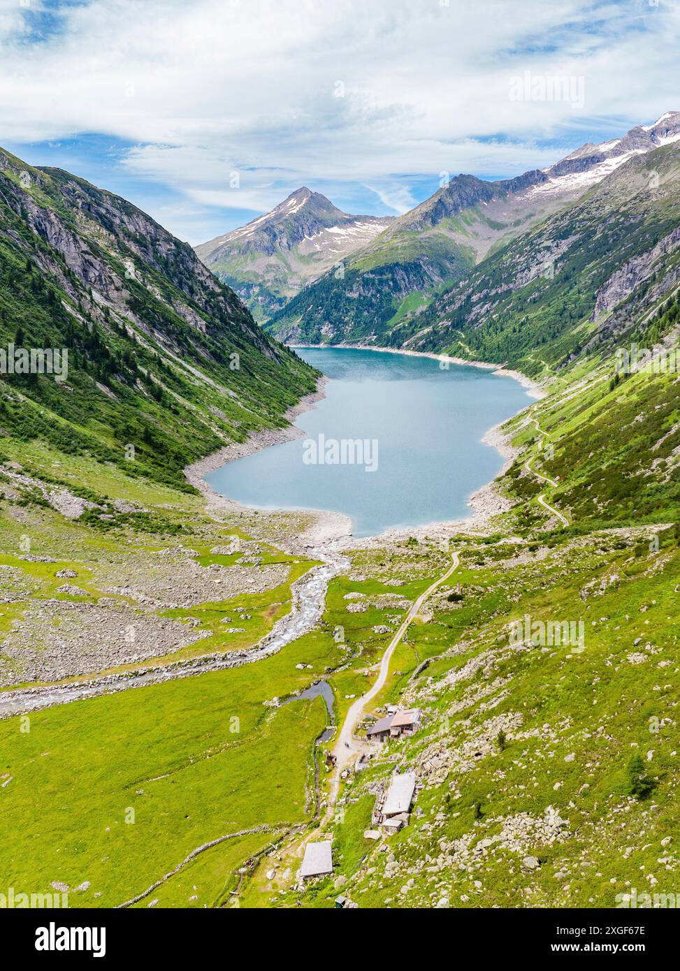 Un panorama de la nature alpine avec un lac de montagne, des prairies verdoyantes, des montagnes, une rivière et un sentier de randonnée sous un ciel nuageux, Klein Tibet, Zillertal Banque D'Images