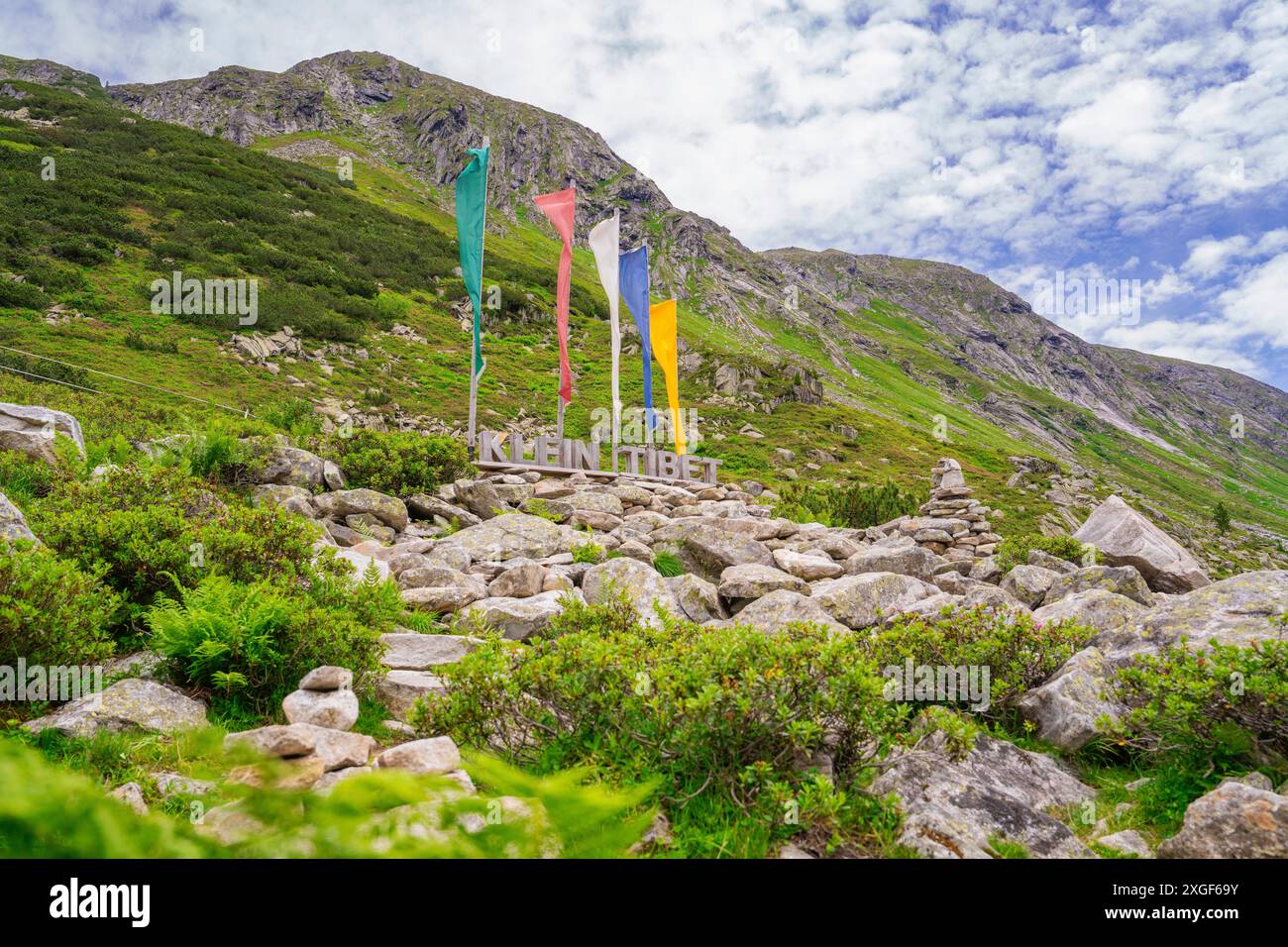 Paysage dans les montagnes avec des drapeaux colorés, un signe et une végétation verte, encadrée par des rochers, petit Tibet, Zillertal, Autriche Banque D'Images