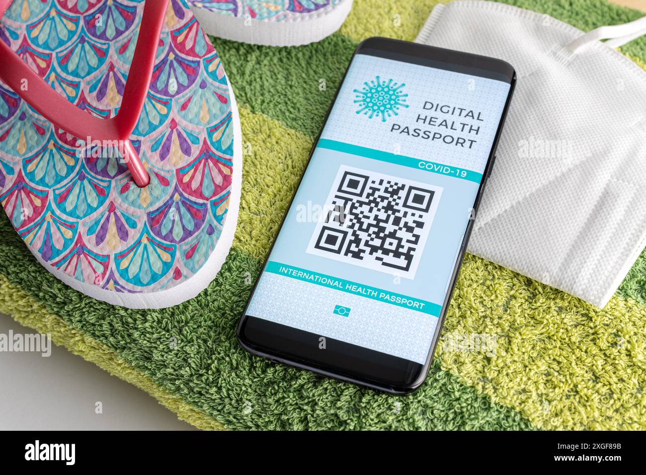 Téléphone intelligent avec passeport numérique de santé ou de vaccination à l'écran, masque facial KN95 et quelques accessoires de plage. Passeport COVID-19 pour voyager sur Banque D'Images